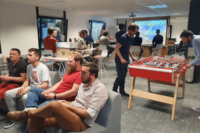 Photo de plusieurs collaborateurs Ntico entrain de jouer aux jeux-vidéos, au babyfoot ou entrain de discuter lors d'un événement en agence.